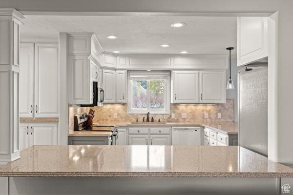 kitchen with appliances with stainless steel finishes, a sink, white cabinetry, recessed lighting, and decorative backsplash