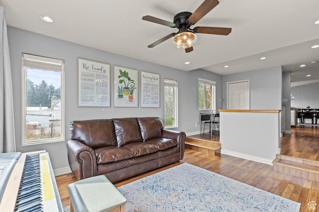 living room with a ceiling fan, baseboards, recessed lighting, and wood finished floors