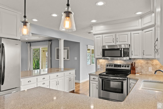 kitchen with decorative backsplash, decorative columns, decorative light fixtures, appliances with stainless steel finishes, and a sink