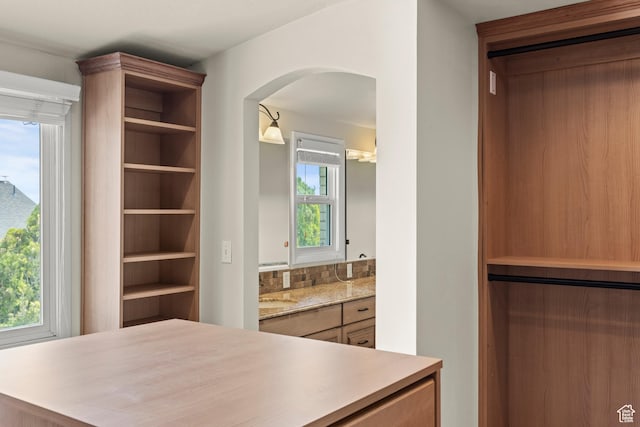 spacious closet featuring arched walkways