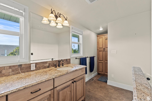 bathroom featuring visible vents, tasteful backsplash, baseboards, vanity, and an inviting chandelier
