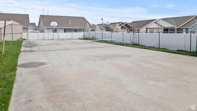 view of car parking featuring a residential view, fence, and community basketball court