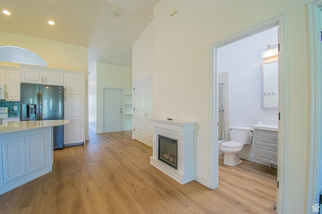 25 Clubhouse Dr, Stansbury Park, UT 84074 - interior space with light countertops, white cabinets, black fridge, and light wood finished floors