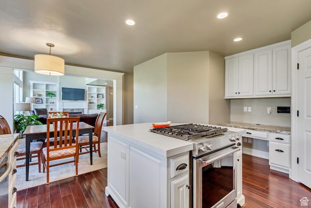 kitchen with white cabinets, stainless steel range, open floor plan, and dark wood-type flooring