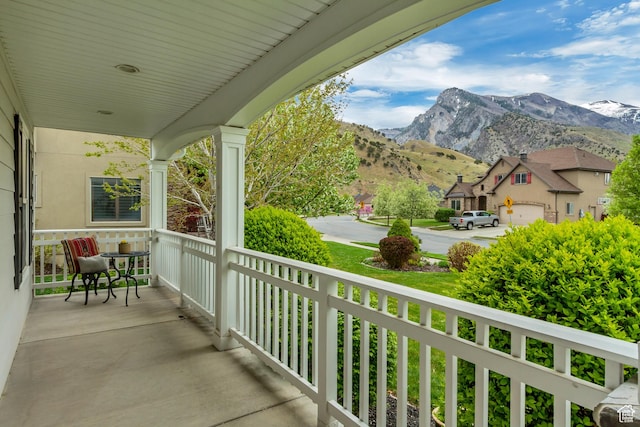 balcony with covered porch and a mountain view
