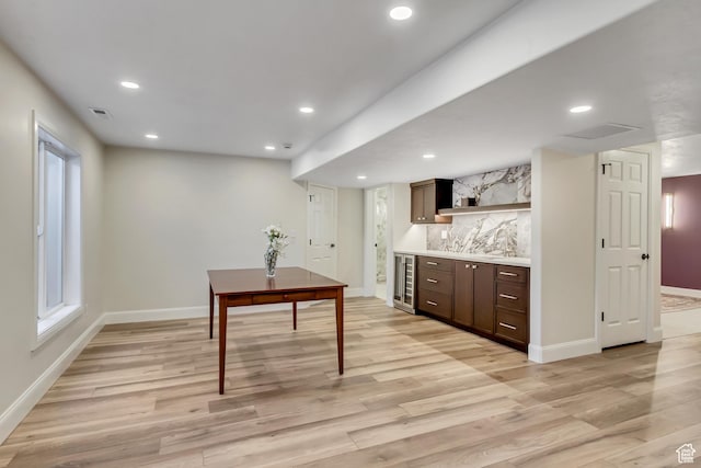interior space with light wood-style floors, recessed lighting, baseboards, and wine cooler