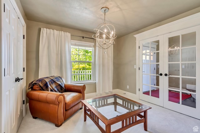 sitting room featuring light colored carpet, a chandelier, and french doors