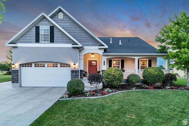craftsman-style home with a garage, covered porch, stone siding, concrete driveway, and a lawn