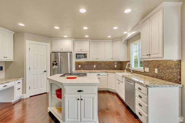 kitchen with dark wood-type flooring, appliances with stainless steel finishes, and white cabinets