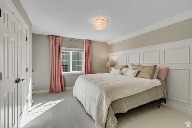 bedroom with light colored carpet and baseboards