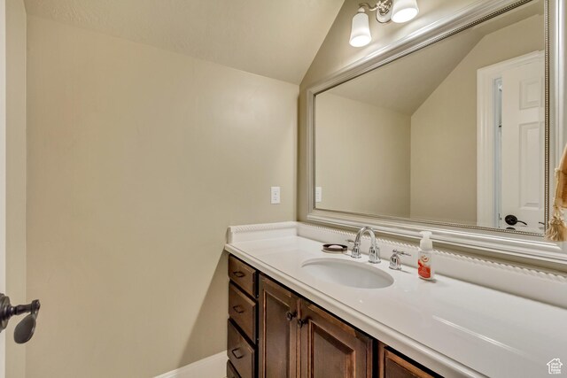 bathroom featuring vanity and lofted ceiling