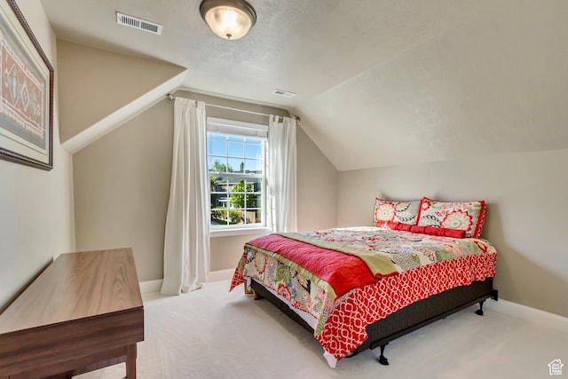 bedroom with visible vents, baseboards, carpet floors, and vaulted ceiling