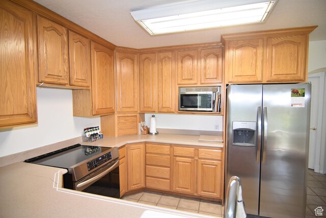 183 E Ama Fille Ln N, Elk Ridge, UT 84651 - kitchen featuring stainless steel appliances, light tile patterned flooring, and light countertops