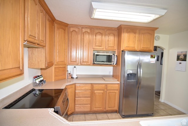 183 E Ama Fille Ln N, Elk Ridge, UT 84651 - kitchen with stainless steel appliances, light tile patterned floors, light countertops, and arched walkways