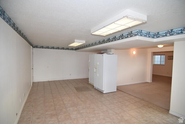 183 E Ama Fille Ln N, Elk Ridge, UT 84651 - below grade area with white fridge with ice dispenser, baseboards, a textured ceiling, and light flooring
