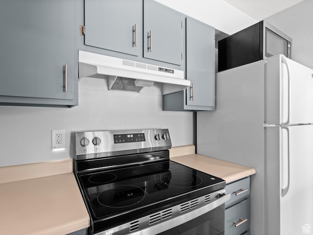 kitchen featuring under cabinet range hood, light countertops, stainless steel electric range oven, and gray cabinetry