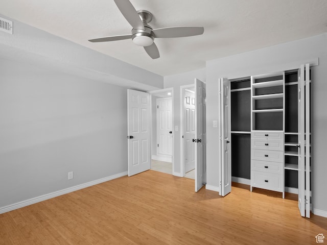 unfurnished bedroom featuring baseboards, light wood-style floors, visible vents, and a ceiling fan