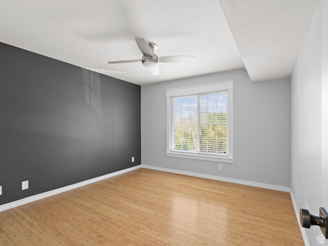 empty room with light wood-style flooring, baseboards, and ceiling fan