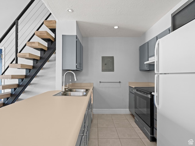 kitchen with electric panel, gray cabinets, freestanding refrigerator, stainless steel electric range, and under cabinet range hood
