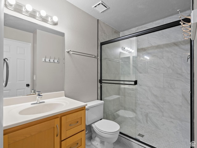 bathroom with toilet, a stall shower, a textured ceiling, visible vents, and vanity
