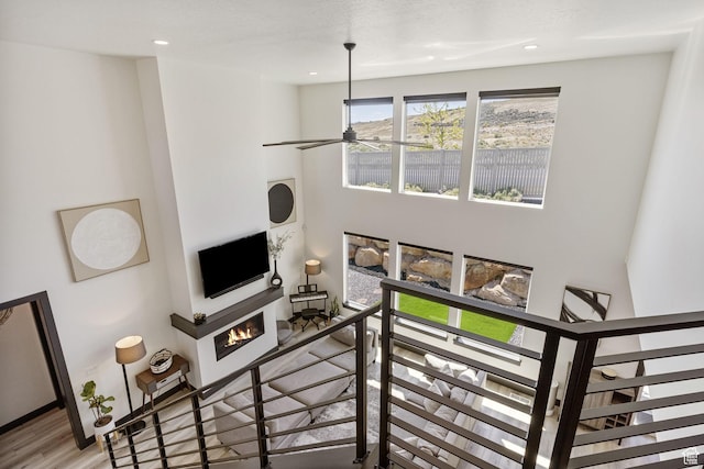 423 W Red Wolf Dr, Saratoga Springs, UT 84045 - living area with recessed lighting, a warm lit fireplace, a ceiling fan, and wood finished floors