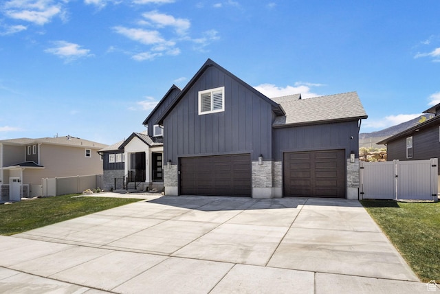 423 W Red Wolf Dr, Saratoga Springs, UT 84045 - modern farmhouse featuring an attached garage, a gate, board and batten siding, a front yard, and driveway