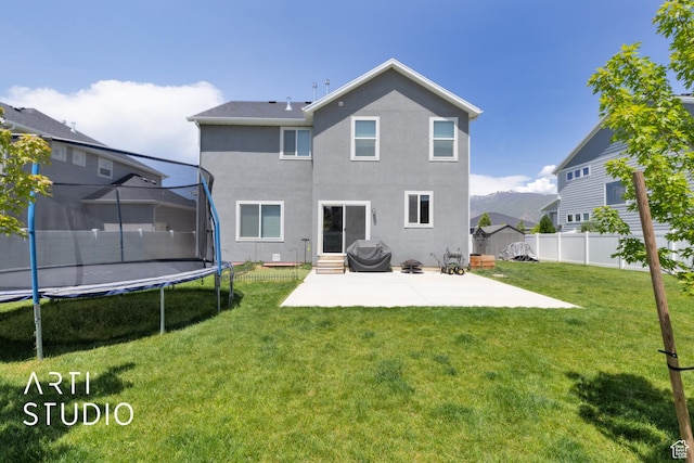 2034 E 970 N, Spanish Fork, UT 84660 - back of property with a trampoline, a patio, stucco siding, and entry steps