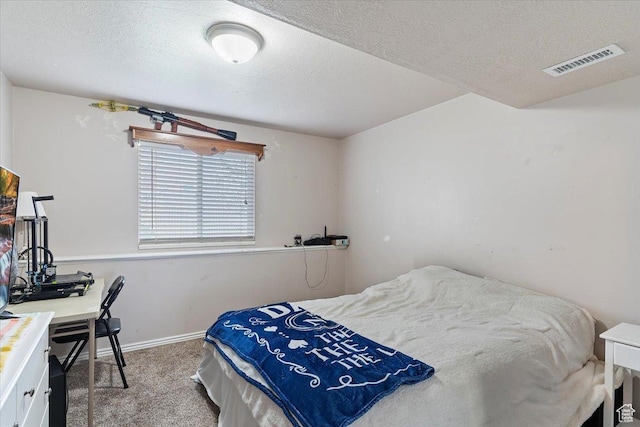 bedroom with a textured ceiling, baseboards, visible vents, and carpet floors