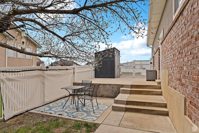 view of patio / terrace featuring fence, a storage shed, and an outbuilding
