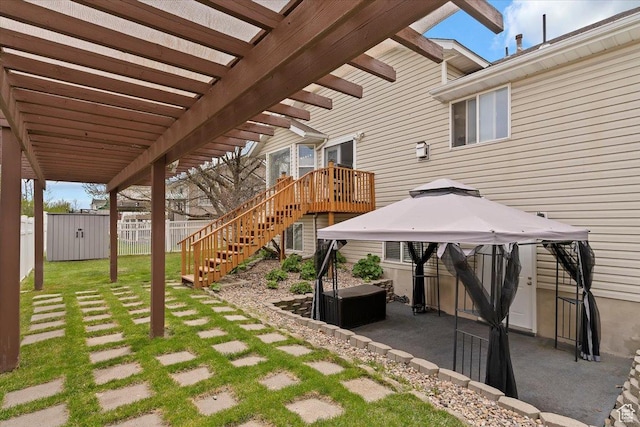 view of patio / terrace with a gazebo, fence, a storage shed, an outbuilding, and a pergola