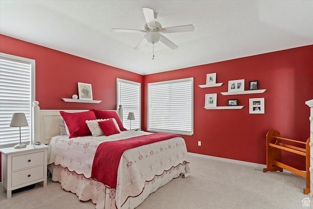 carpeted bedroom featuring wainscoting and ceiling fan