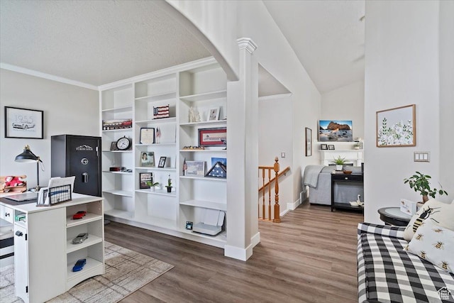 office area featuring wood finished floors, a textured ceiling, baseboards, arched walkways, and ornamental molding