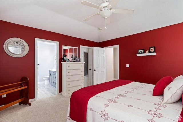 bedroom featuring ceiling fan, carpet flooring, ensuite bathroom, and baseboards