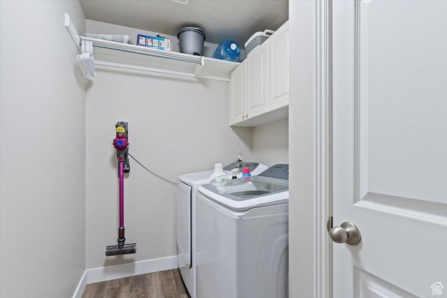 laundry room featuring baseboards, dark wood-style flooring, cabinet space, and washer and clothes dryer