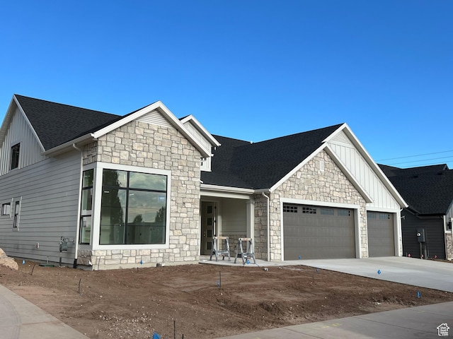 1148 N 1875 E Unit 2, Layton, UT 84040 - view of front facade with board and batten siding, stone siding, an attached garage, driveway, and a shingled roof