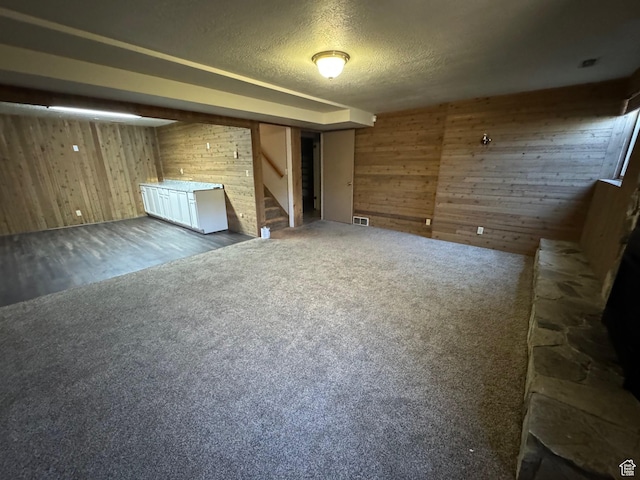 281 N Pin Oak Cir, Kaysville, UT 84037 - unfurnished living room featuring a textured ceiling, wood walls, visible vents, and stairs
