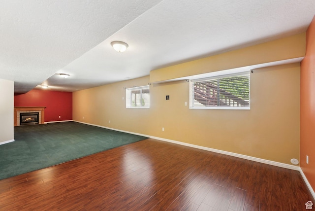 basement featuring a tile fireplace, wood finished floors, and baseboards