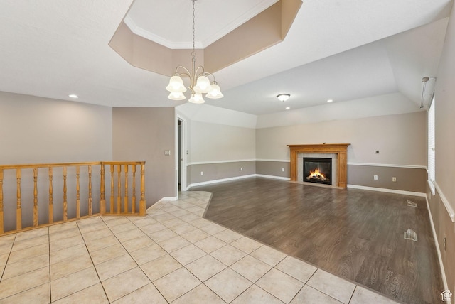 unfurnished living room featuring a tiled fireplace, a notable chandelier, tile patterned floors, baseboards, and recessed lighting