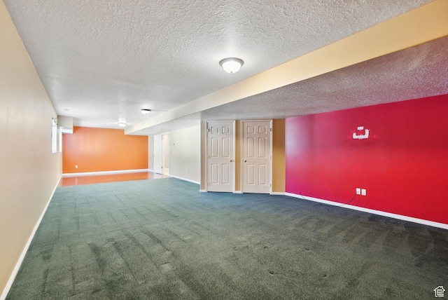 basement featuring carpet flooring, a textured ceiling, and baseboards