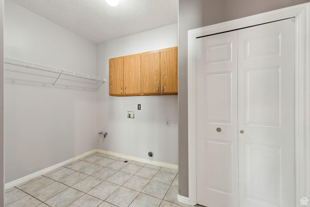 laundry area featuring electric dryer hookup, cabinet space, washer hookup, baseboards, and light tile patterned flooring