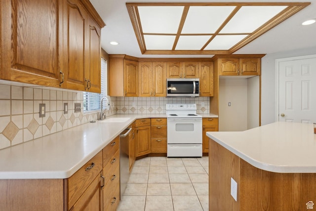 kitchen featuring a sink, brown cabinetry, stainless steel appliances, and light countertops