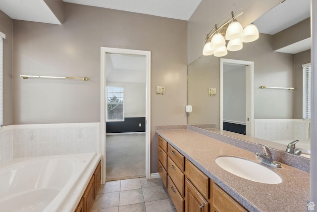 bathroom featuring baseboards, tile patterned floors, vanity, and a bath