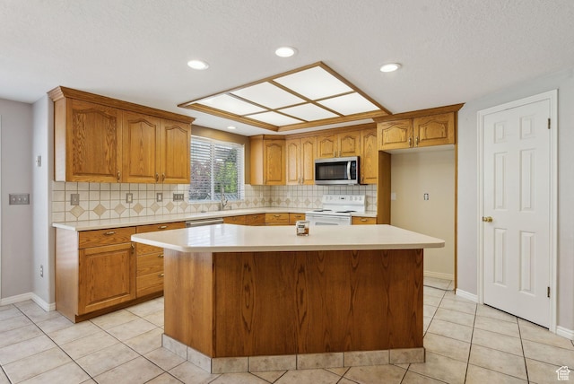 kitchen featuring light countertops, a center island, electric stove, and stainless steel microwave