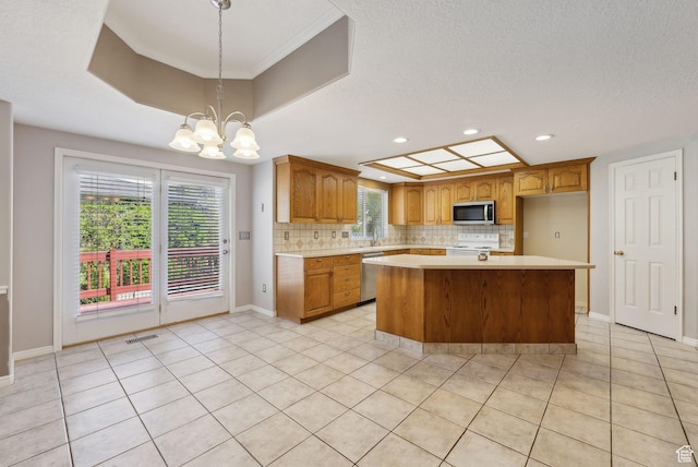 kitchen featuring recessed lighting, decorative backsplash, light countertops, a notable chandelier, and appliances with stainless steel finishes