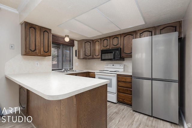 1314 E 1990 S, Ogden, UT 84401 - kitchen with freestanding refrigerator, black microwave, a peninsula, light countertops, and electric range