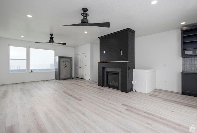 11056 S Lake Run Rd, South Jordan, UT 84009 - unfurnished living room with a ceiling fan, light wood finished floors, and a fireplace