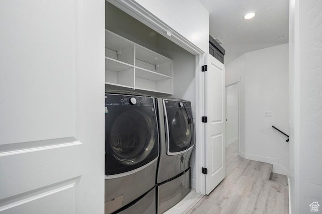 11056 S Lake Run Rd, South Jordan, UT 84009 - laundry area featuring laundry area, washing machine and clothes dryer, a textured ceiling, baseboards, and light wood-style floors
