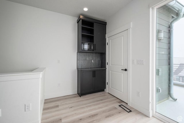 11056 S Lake Run Rd, South Jordan, UT 84009 - interior space featuring light wood-style flooring, tasteful backsplash, baseboards, and black microwave