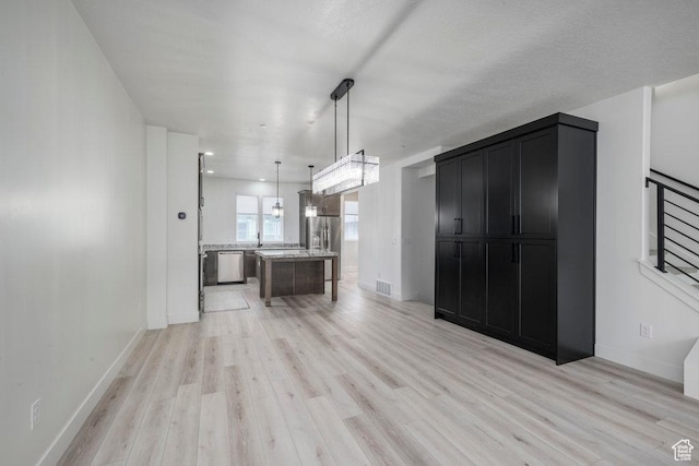 11056 S Lake Run Rd, South Jordan, UT 84009 - kitchen with decorative light fixtures, light wood finished floors, dark cabinets, visible vents, and appliances with stainless steel finishes