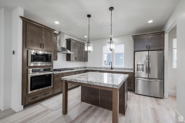 11056 S Lake Run Rd, South Jordan, UT 84009 - kitchen featuring light wood-style flooring, a sink, dark brown cabinetry, wall chimney range hood, and stainless steel appliances